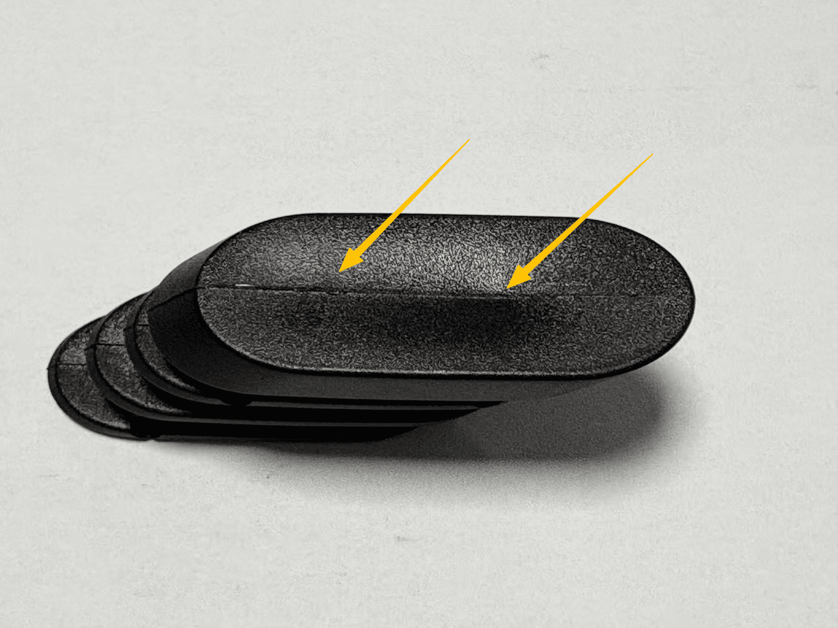 A close-up image of a plastic part showing a clear sink mark on its surface.